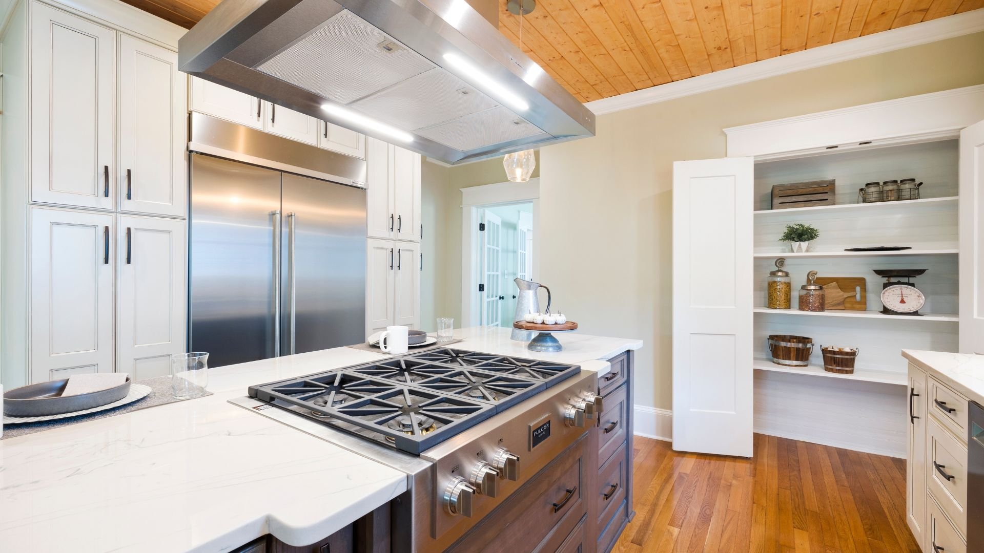 Modern white kitchen with stainless steel appliances and wooden floor